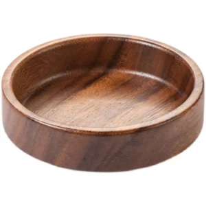 Solid wood round dessert plate holding delicate French macarons on a minimalist Japanese style coffee table.