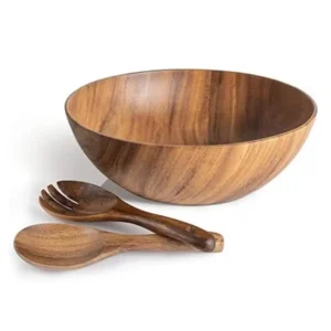 Solid acacia wood serving bowl filled with a large fresh garden salad on a modern family table.
